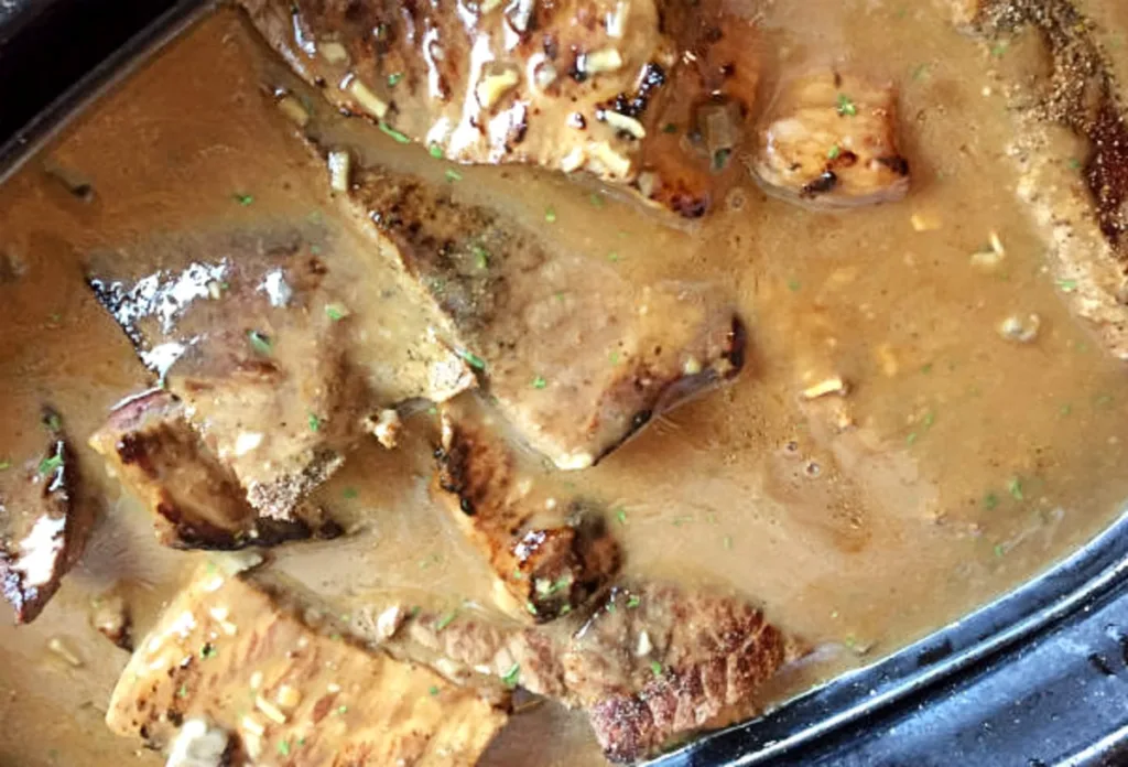 Browned steak pieces covered in rich gravy and ready to bake until tender — classic baked steak smothered in savory sauce
