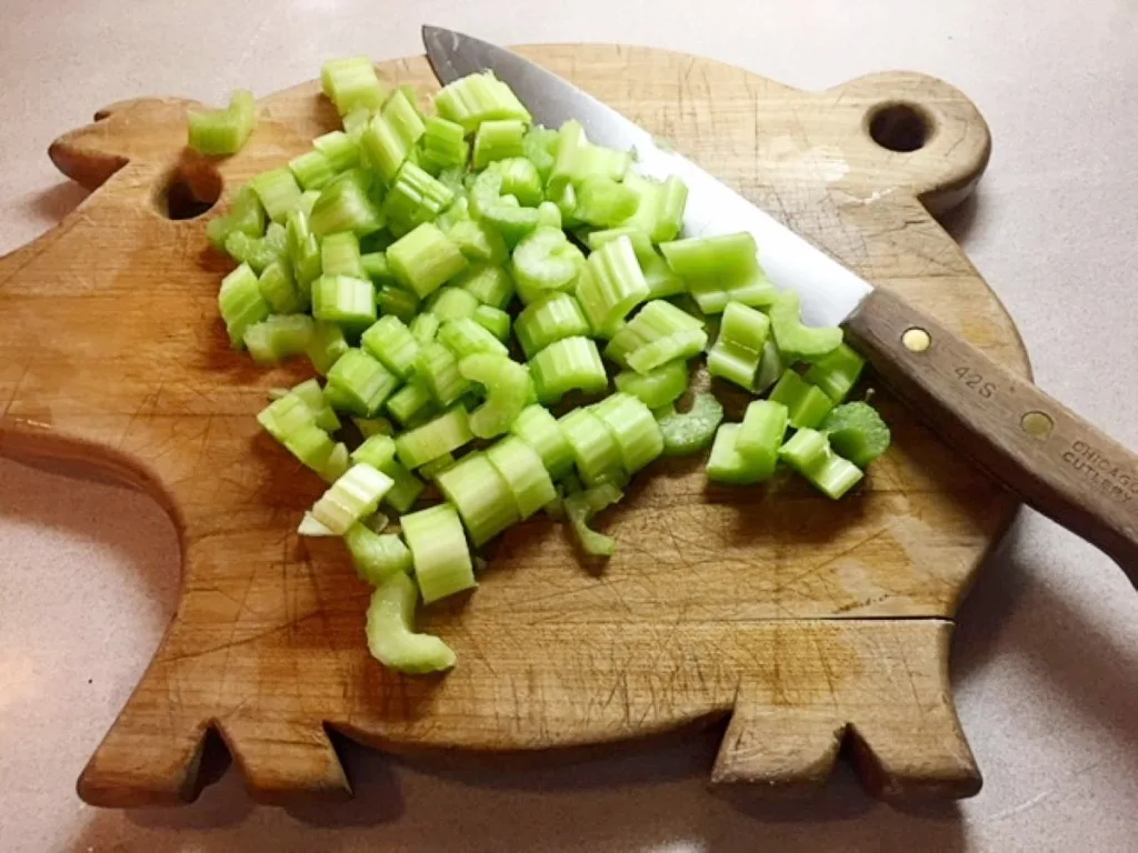 thickly sliced celery on a pig-shaped wooden cutting board