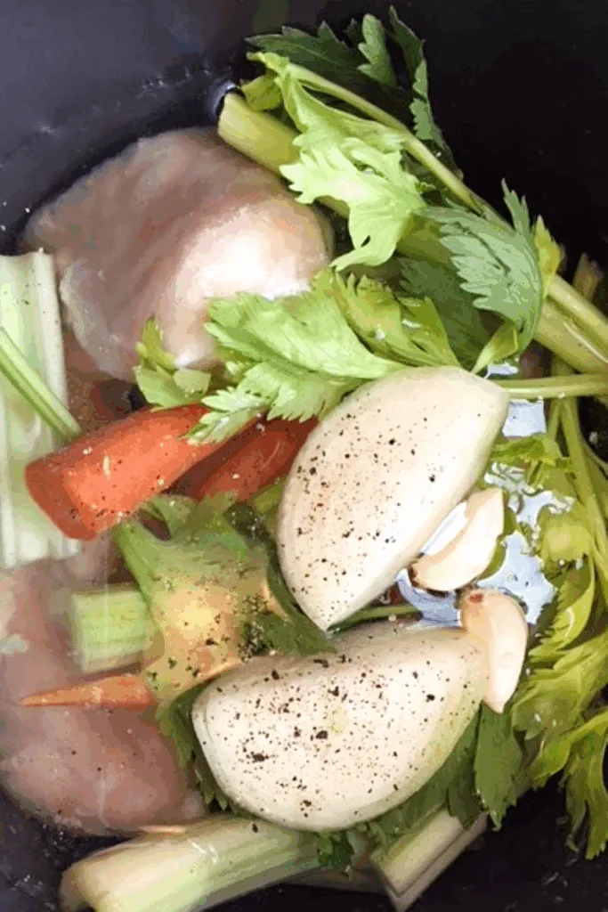 frozen chicken breasts with carrots, celery, onion, garlic and black pepper ready to simmer