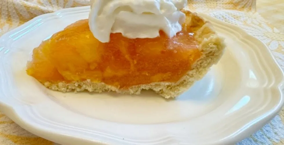 a piece of fresh peach pie on a white plate