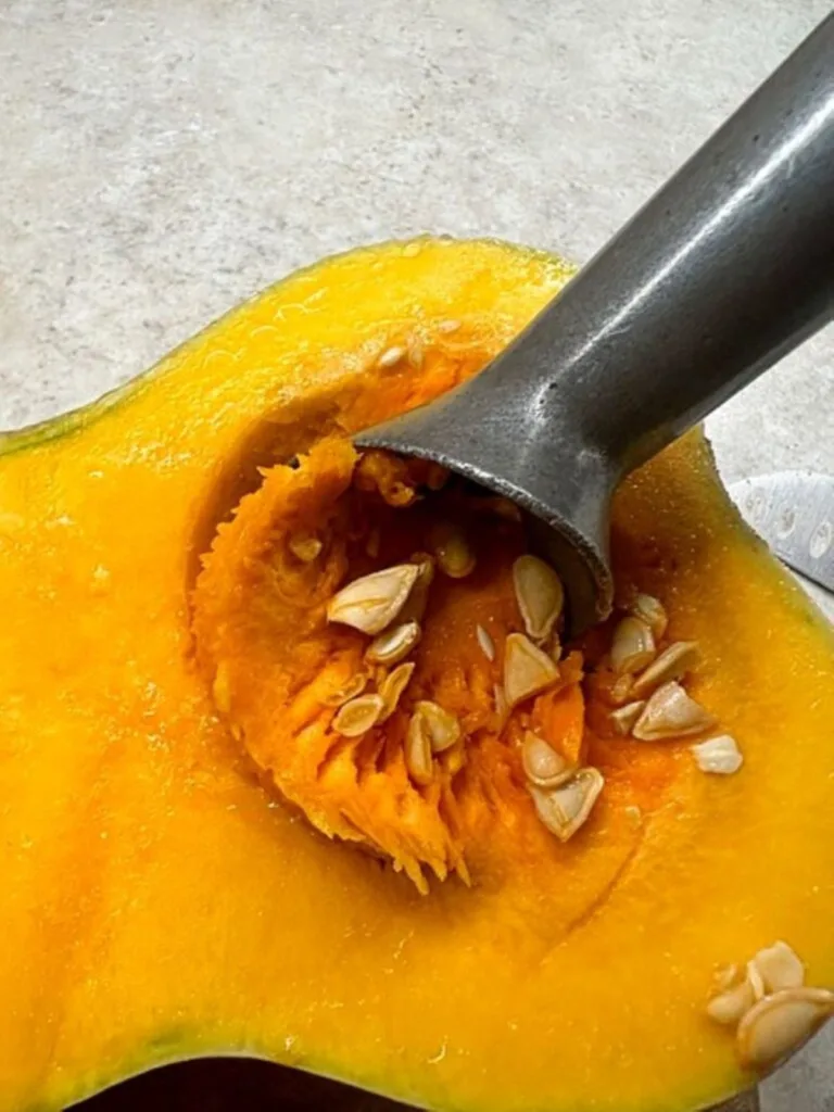 scooping seeds out of butternut squash