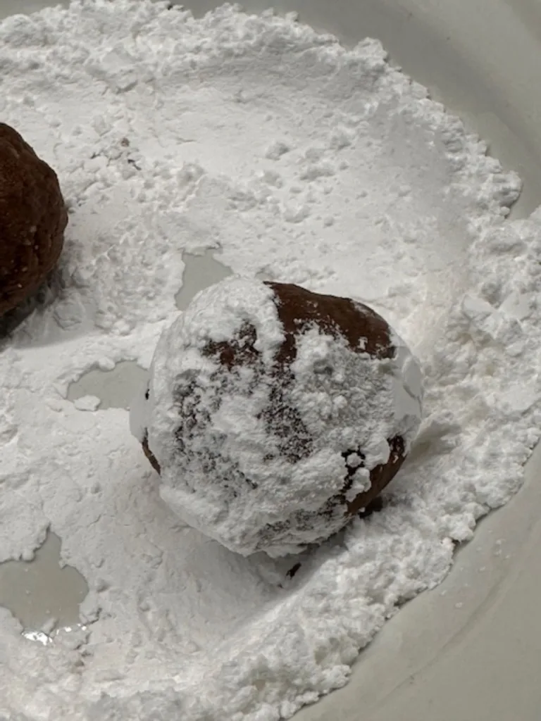 rool amaraetto booze balls in powdered sugar

