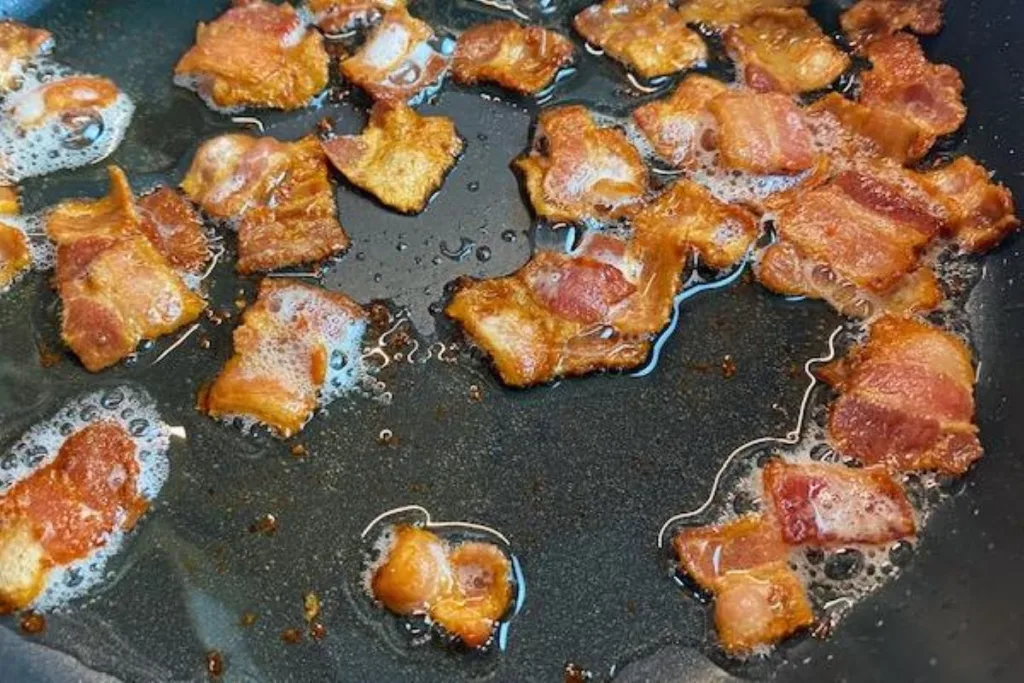 Hormel Black label Bacon pieces frid in a skillet
