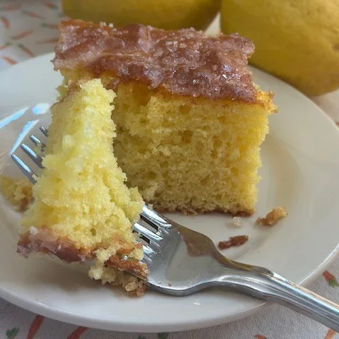 moist tender lemon cake on a plate with a fork -ready to take a bite