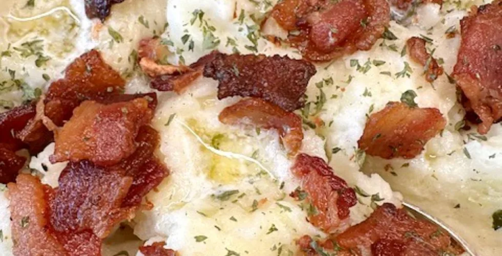 close up of colcannon showing the creamy potato-cabbage mixture, pools of melted butter and crisp bacon