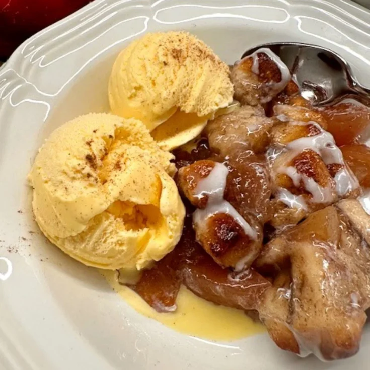 apple coffee cake served with two scoops of vanilla ice cream