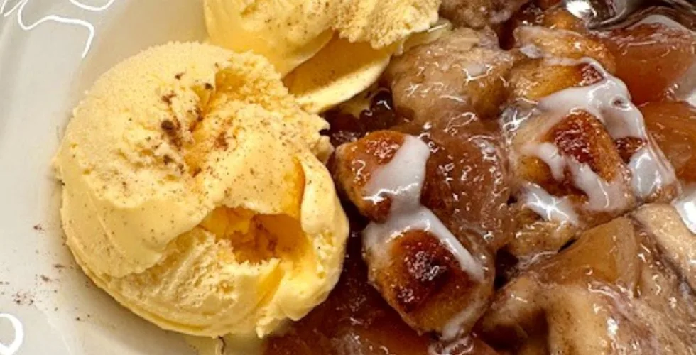 apple coffee cake served with two scoops of vanilla ice cream