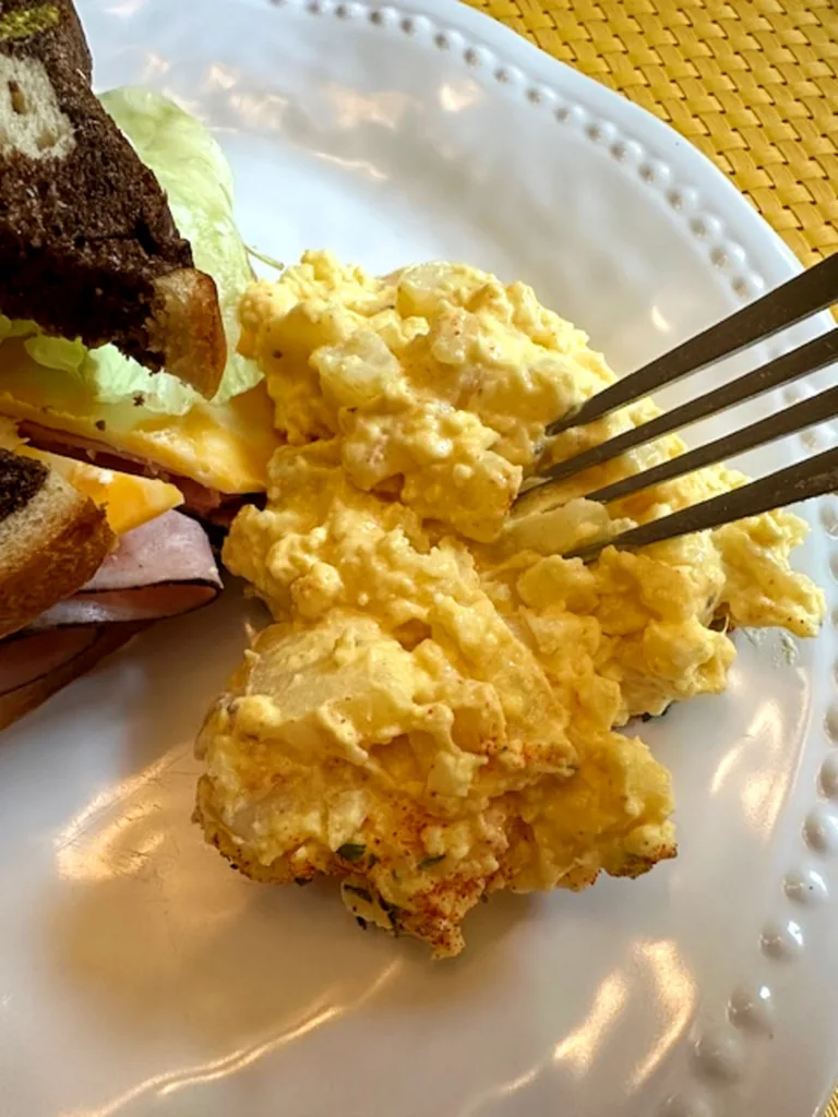 old-fashioned grandma-style potato salad on a plate next to a sandwich
