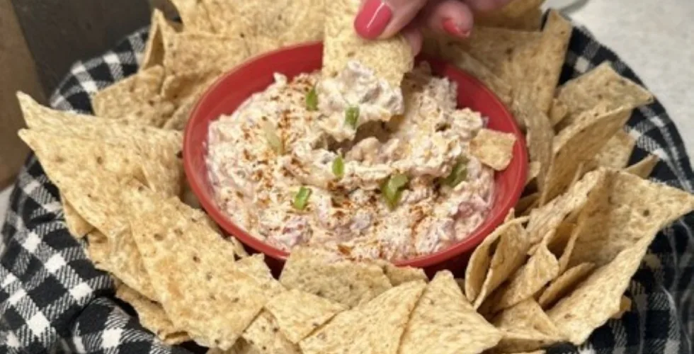 dipping a tortilla chip into the boat dip