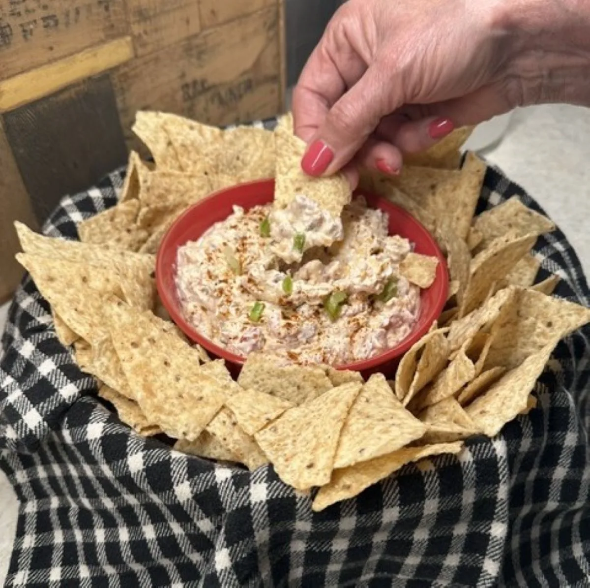 dipping a tortilla chip into the boat dip