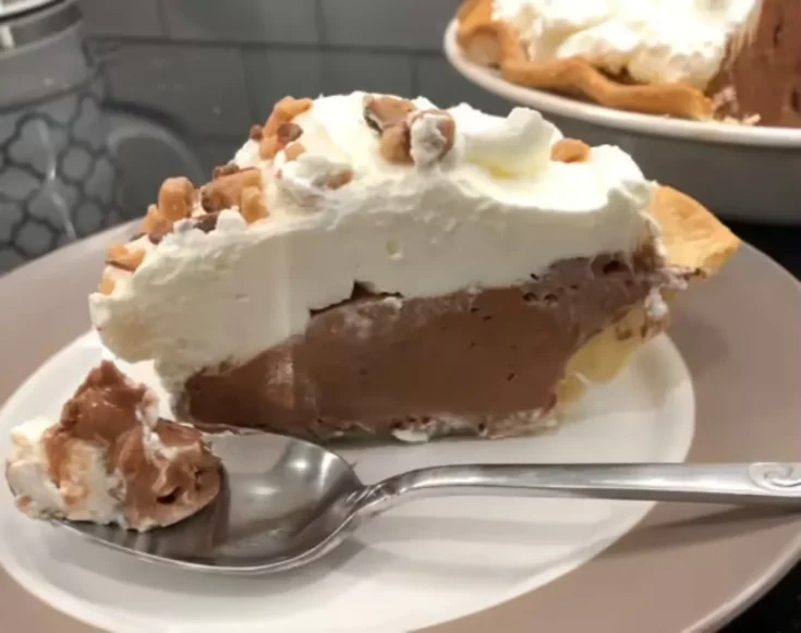 piece of French silk pie on a white plate with fork - ready to take one bite