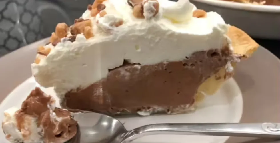 piece of French silk pie on a white plate with fork - ready to take one bite